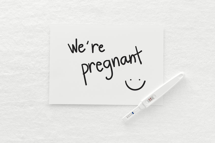 Positive pregnancy test with a "We're pregnant" note